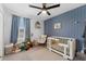 Blue-accented Bedroom with a crib, rocking chair, plush toys and natural light at 7509 S Sherrill St, Tampa, FL 33616