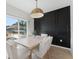 Bright dining room features modern lighting, black accent wall, and sliding doors to the pool at 7509 S Sherrill St, Tampa, FL 33616