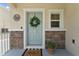 Close-up of a light blue front door with decorative wreath at 7509 S Sherrill St, Tampa, FL 33616