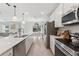 Well-equipped kitchen with stainless steel appliances, bright lighting, and seamless flow to dining area at 7509 S Sherrill St, Tampa, FL 33616