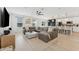 Living room with kitchen view, featuring hardwood floors, a large sectional couch, and natural light at 7509 S Sherrill St, Tampa, FL 33616