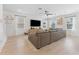 Open living room with hardwood floors, a large sectional couch, and natural light at 7509 S Sherrill St, Tampa, FL 33616