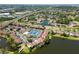 An aerial view of a lakeside community with lush landscaping, tennis courts, and a community pool at 782 Village Lake N Ter # 102, St Petersburg, FL 33716