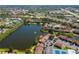 Aerial view of property showcasing lake, community pools and mature landscaping at 782 Village Lake N Ter # 102, St Petersburg, FL 33716