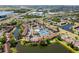 Overhead view of a lakeside condo community featuring mature trees, ample parking, tennis courts, and a shared pool at 782 Village Lake N Ter # 102, St Petersburg, FL 33716
