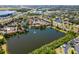 An aerial view of a lakeside community with lush landscaping and a serene fountain in the middle of the lake at 782 Village Lake N Ter # 102, St Petersburg, FL 33716
