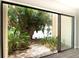 Backyard view through sliding glass doors featuring lush trees and landscape at 782 Village Lake N Ter # 102, St Petersburg, FL 33716