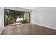 Bright bedroom featuring luxury vinyl flooring and a sliding glass door with scenic outdoor view at 782 Village Lake N Ter # 102, St Petersburg, FL 33716