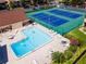 Overhead view of the community pool, tennis courts, and clubhouse showcasing the community's recreational amenities at 782 Village Lake N Ter # 102, St Petersburg, FL 33716