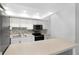 Galley kitchen featuring a mosaic backsplash, stainless steel appliances and white cabinets at 782 Village Lake N Ter # 102, St Petersburg, FL 33716
