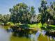 Lake view with mature trees reflecting in the water highlighting the condo complex at 782 Village Lake N Ter # 102, St Petersburg, FL 33716