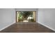 Inviting living room with wood floors and sliding glass doors overlooking a mature tree and lush landscaping at 782 Village Lake N Ter # 102, St Petersburg, FL 33716