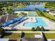 Aerial view showcasing a pool, tennis court, and playground with sunshades, all within the community at 8105 Bilston Village Ln, Gibsonton, FL 33534