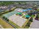 Aerial view showcasing the basketball and tennis courts, playground with sunshades, and the community pool at 8105 Bilston Village Ln, Gibsonton, FL 33534