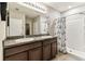 Bathroom boasts double sinks, a granite countertop, and a tiled shower with a curtain at 8105 Bilston Village Ln, Gibsonton, FL 33534