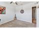 Bright bedroom features soft carpet, a round mirror, and doorway at 8105 Bilston Village Ln, Gibsonton, FL 33534