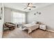 Bedroom with neutral walls and flooring, large window, and ceiling fan at 8105 Bilston Village Ln, Gibsonton, FL 33534