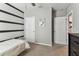 Cozy bedroom featuring stylish striped wall design and doorway at 8105 Bilston Village Ln, Gibsonton, FL 33534