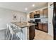 The kitchen features stainless steel appliances, granite countertops, a center island with seating and brown cabinets at 8105 Bilston Village Ln, Gibsonton, FL 33534