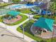 Aerial view showcasing two playgrounds, with a pool, tennis court, and community center in the background at 8105 Bilston Village Ln, Gibsonton, FL 33534