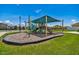 Community playground featuring a covered play structure, slide, climbing equipment, and mature landscaping at 8105 Bilston Village Ln, Gibsonton, FL 33534