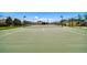 Community tennis court featuring a net, fencing, lighting, and professional court markings at 8105 Bilston Village Ln, Gibsonton, FL 33534