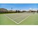 Community tennis court featuring a net, fencing, lighting, and professional court markings at 8105 Bilston Village Ln, Gibsonton, FL 33534