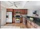 Well-lit kitchen with stainless steel appliances, wooden cabinets, and beautiful dark countertops at 936 Pinellas Bayway S # T-5, Tierra Verde, FL 33715