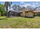 The backyard features a screened-in pool, lush landscaping, and exterior home details like a red tile roof and chimney at 9611 125Th N St, Seminole, FL 33772