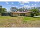 The spacious backyard showcases the home's exterior, featuring a tile roof, a screened-in pool, and landscaping at 9611 125Th N St, Seminole, FL 33772
