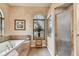 Serene bathroom features a soaking tub, arched window, and a glass-enclosed shower at 9611 125Th N St, Seminole, FL 33772