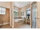 Bathroom showcasing a soaking tub, arched window, and natural light at 9611 125Th N St, Seminole, FL 33772