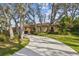 Elegant home with a long, winding driveway, lush landscaping and mature trees providing privacy at 9611 125Th N St, Seminole, FL 33772