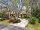 Beautiful home with a curved driveway, lush gardens, and mature trees offering a private setting at 9611 125Th N St, Seminole, FL 33772