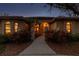 Stucco home with a red tile roof, manicured landscaping, and an arched front entrance at dusk at 9611 125Th N St, Seminole, FL 33772