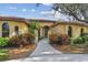 Stucco home with a red tile roof, manicured landscaping, and an arched front entrance at 9611 125Th N St, Seminole, FL 33772