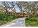 Lovely house with a red tile roof, luscious bushes, and shaded by sprawling trees at 9611 125Th N St, Seminole, FL 33772