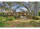 Charming home with a red tile roof, lush landscaping, and mature trees at 9611 125Th N St, Seminole, FL 33772