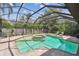 Enclosed pool and spa area with a screened enclosure, lush landscaping and brick paver surround at 9611 125Th N St, Seminole, FL 33772
