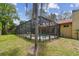 A screened-in pool sits adjacent to the home under a red tile roof and offers privacy with lush landscaping at 9611 125Th N St, Seminole, FL 33772