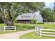 Charming exterior view of home featuring a metal roof, covered porch, and lush green lawn with mature trees at 10101 Bryant Rd, Lithia, FL 33547