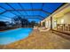 Covered in-ground pool with stone patio, perfect for outdoor gatherings at 10101 Bryant Rd, Lithia, FL 33547