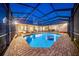 Inviting pool area with brick surround, covered enclosure, and comfortable seating under a twilight sky at 10101 Bryant Rd, Lithia, FL 33547