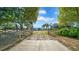 Gated property with a long driveway leading to a large barn, surrounded by lush greenery at 10101 Bryant Rd, Lithia, FL 33547
