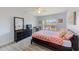 Bright bedroom with a large window, ceiling fan, dark dresser, and laminate floors at 10215 Regal Dr # 41, Largo, FL 33774