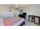 Bright bedroom with a dark dresser and desk, ceiling fan, neutral walls, and laminate floors at 10215 Regal Dr # 41, Largo, FL 33774