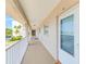 Hallway leading to unit door with white railings and views of palm trees in the background at 10215 Regal Dr # 41, Largo, FL 33774