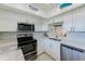 Well-lit kitchen featuring modern appliances, white cabinets, and stunning backsplash at 10215 Regal Dr # 41, Largo, FL 33774