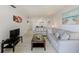 Comfortable living room featuring tile flooring, a stylish glass coffee table and neutral-toned furniture at 10215 Regal Dr # 41, Largo, FL 33774