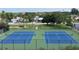 View of the community tennis courts surrounded by lush trees at 10215 Regal Dr # 41, Largo, FL 33774